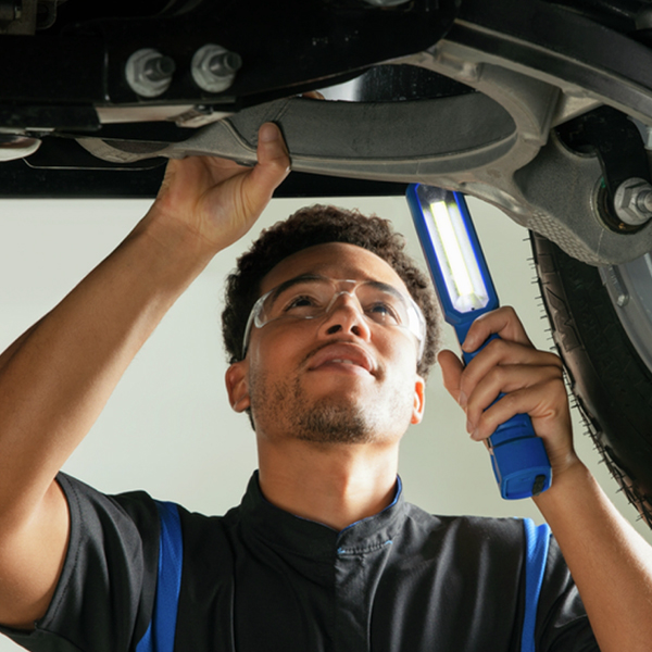Service technician looking under a car