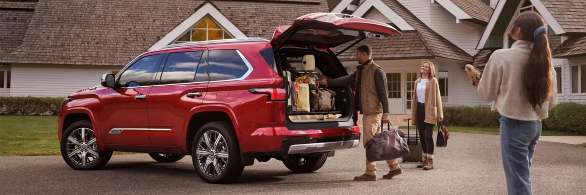happy family loading luggage in the trunk of a Toyota