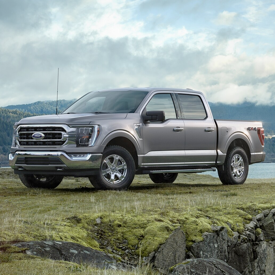 A 2023 Ford F-150® on a grassy cliff near a lake