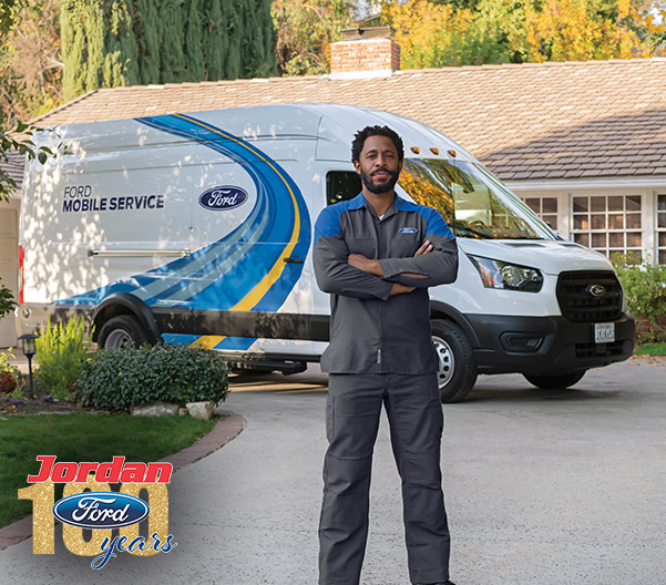 Ford Mobile service man standing in front of his parked Ford van with a residential home behind it