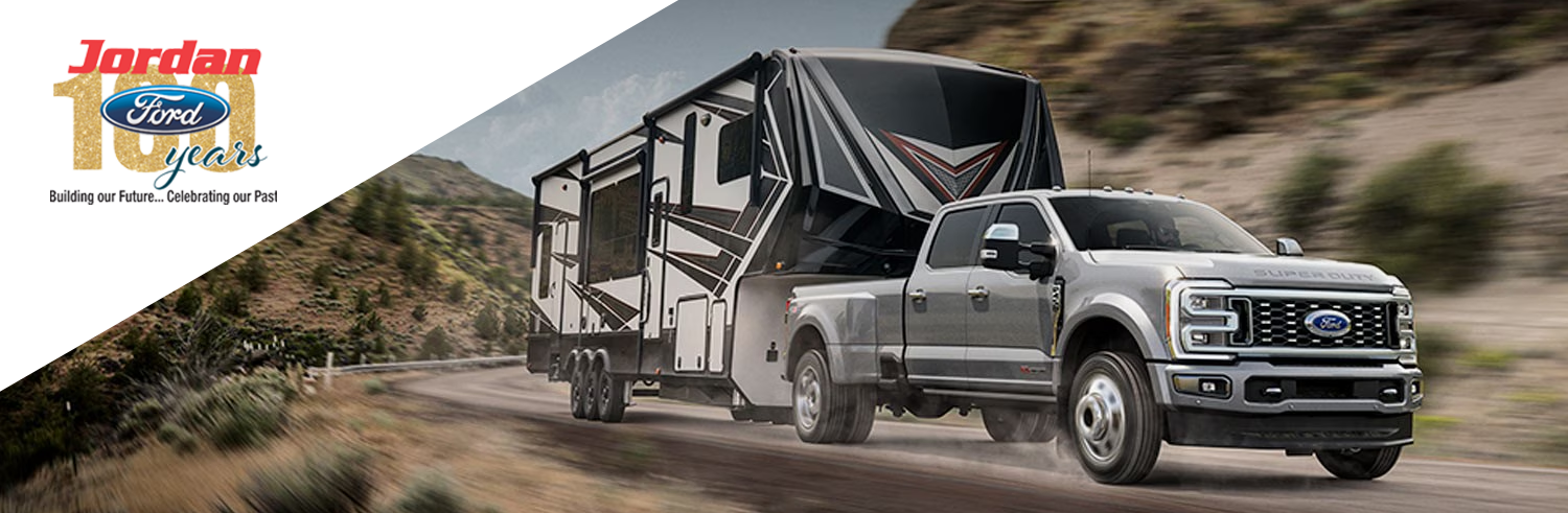 2024 Ford Super Duty® F-450® Limited DRW model pulling a camper trailer on a mountain road