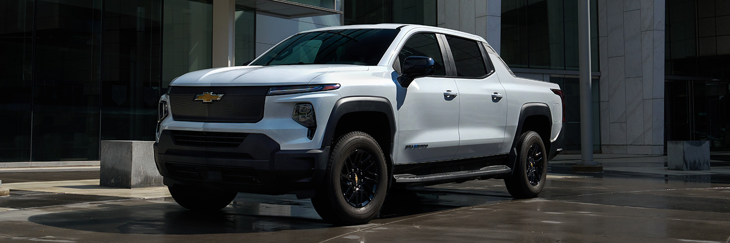 Front 3/4 shot of the Chevrolet Silverado EV parked in front of building