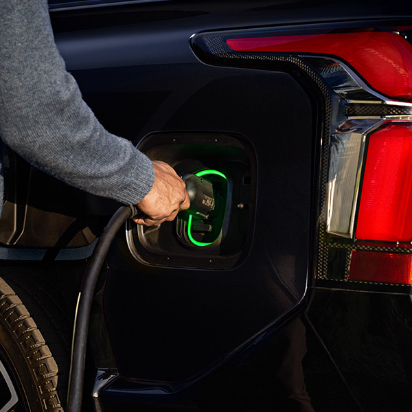 Close up shot of man plugging in charger to Chevrolet Silverado EV